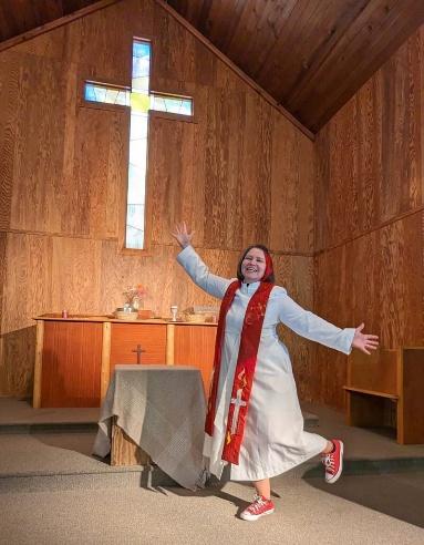 Woman posing next to a cross